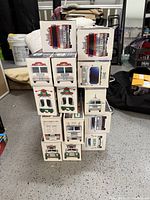 14 Hess toy trucks and vehicles stacked in original boxes showing front and side box art