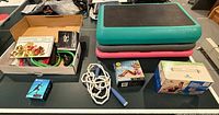 Full lot overview showing step platforms, jump ropes, resistance bands, DVDs, ankle weights