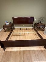 King size sleigh bed frame assembled in the room showing the headboard, footboard, and central metal support rails.