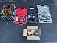 Full lot overview with all pneumatic tools, hoses, and parts displayed on asphalt surface.