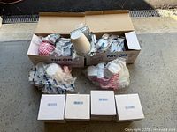 Five Nicor recessed lighting fixtures in original boxes and plastic packaging along with trims in smaller boxes.