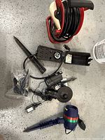 All items laid out on floor including extension cord reel, timer, and three projection lights with stakes, cables and control boxes visible.