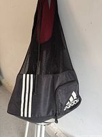 Black and gray Adidas ball bag with mesh fabric and Adidas logo, minor signs of wear visible