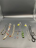 Overall view showing all necklaces, rings, brooches, and mini silver baskets.