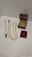 Full lot with two necklaces, two pearl items in their boxes/pouches