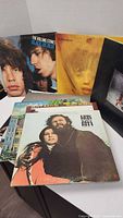 Photo showing multiple vinyl records including The Rolling Stones Black and Blue, Goats Head Soup, and others, giving an overview of record covers and condition.
