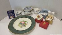 Full view of the collection showing plate, bowls, creamer, sugar bowl, commemorative boxes and tin