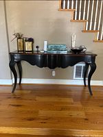 Full view of black Grange console table with decorative items on top