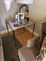End table shown with decorative items on top including lamp, photo frames, and vase.
