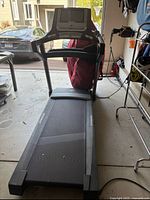 Full view of the treadmill from the running belt side showing the walking surface, side rails, and front motor housing area.