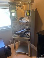 Front view of tall mirrored jewelry cabinet showing decorative mirrored door design