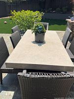 Overhead view of rectangular Ventana cement dining table with plant centerpiece and surrounding chairs