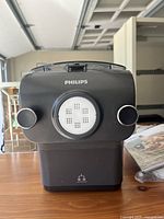 Front view of the black Philips pasta machine showing brand name and control knobs.