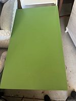 Overhead view of the green rectangular desk top showing minor surface wear.