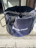 Solo Stove carrying cover in black nylon with handles and drawstring closure, displaying the Solo Stove logo on the side.