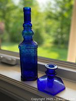 Bottle and candle holder together showing color and forms