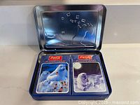 Open tin showing two sealed decks inside