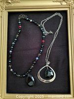 Both necklaces laid out in frame for overall view