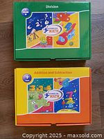 Top view of both boxed kits: green Division and orange Addition & Subtraction