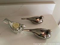 Three silver ceramic birds, two doves and one tealight holder