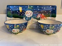 Front view of tray and two bowls displaying snowman design