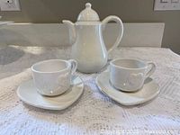 Teapot, two cups and two heart-shaped saucers displayed together