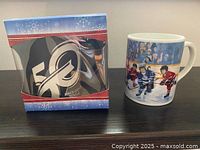 50th Anniversary mug in holiday window box beside Winning Goal mug