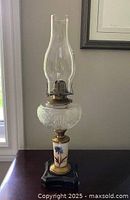 Full view of assembled kerosene lamp showing chimney, font, column, and base