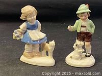 Two porcelain figurines, girl with cat and boy with dog, each approximately 4.5 inches high.