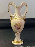 Front view of floral hand painted porcelain vase, showing floral designs and gold accents with double handles.