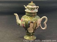 Full view of a green Limoges teapot with gold leaf decoration, a portrait of a woman, and a miniature teapot as a lid top.