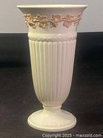Full view of Wedgwood vase showing fluted body and raised grapevine decoration near rim.