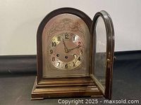 Front angle of the wooden box clock with door open showing glass front and clock face.