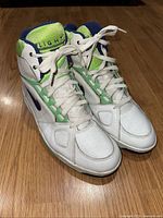 Front pair view showing white leather with neon green and navy blue accents, white laces, and visible wear on toe box.