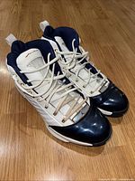Full pair of 2004 Air Jordan 19 SE USA Olympic white, gold, navy sneakers showing overall wear and color scheme.