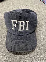 Front view of black corduroy SnapBack hat with white embroidered FBI letters on front.