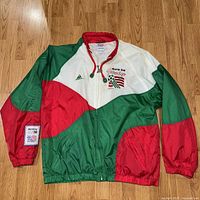 Front full view of the windbreaker jacket showing colorblock design and embroidery