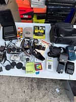 Top view of the complete camera lot showing vintage cameras, lenses, cases, and film rolls.