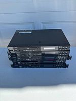 Stack of four Denon DN-500BD MKII units showing front and top surfaces.