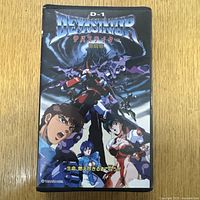 Front cover of VHS showing detailed anime characters and mech in vibrant colors with Japanese text.