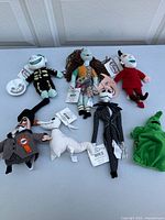 Full lot display of seven Nightmare Before Christmas plush beanie bags on table showing all characters except close detail