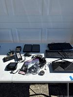 Full lot on white table including tablets, keyboards, mice, and assorted electronics