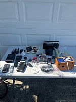 Full view of table containing all electronics and accessories, viewed outside under sunlight