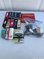 Top view of the golf balls collection and accessories on white table showing boxes and loose items in a plastic bag.