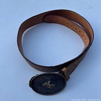 Full view of brown leather belt with attached sterling silver overlay buckle