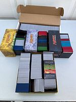 Five Magic: The Gathering cardboard deck boxes filled with bulk cards
