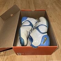 Nike Air Flight Elevate NC men's basketball shoes in blue and white inside original orange Nike box, shown from side and top angles to highlight condition.