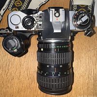 Top view of the Pentax ME Super camera showing the body, attached Takumar lens with aperture and zoom markings, power winder grip, and strap.