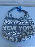 Full view of the Robin Ruth branded tote bag with New York themed text pattern in black and white.