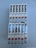 Top-down view of the 12 sealed Scotch head cleaning VHS tapes in two rows of six, showing spines with brand and product name.